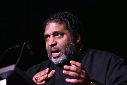 Reverend William Barber on stage speaking to an audience
