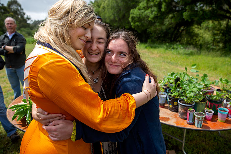 Tanya Hanson (left), Skye Michel and Leah Jones hug outside