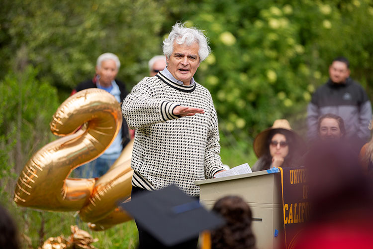 Ignacio Chapela stands in front of podium out side during the CRS Alternative graduation ceremony