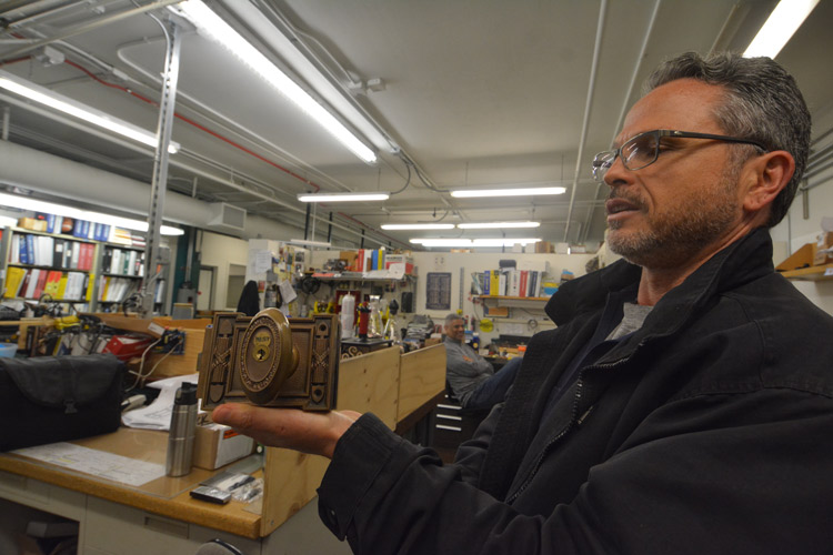 Jeff Bovie displays an antique-style ADA-approved door handle and lock for Durant Hall.