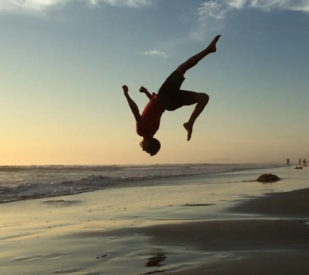 Tyler doing a flip on the beach.