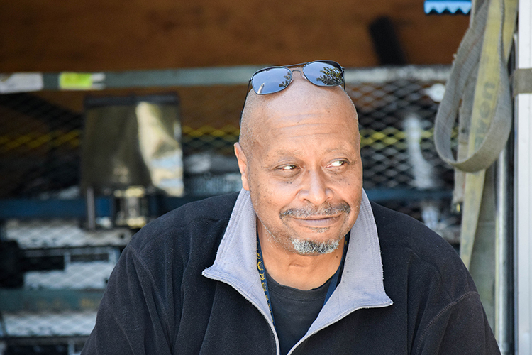 Portrait of Jim smiling while sitting in the back of his truck