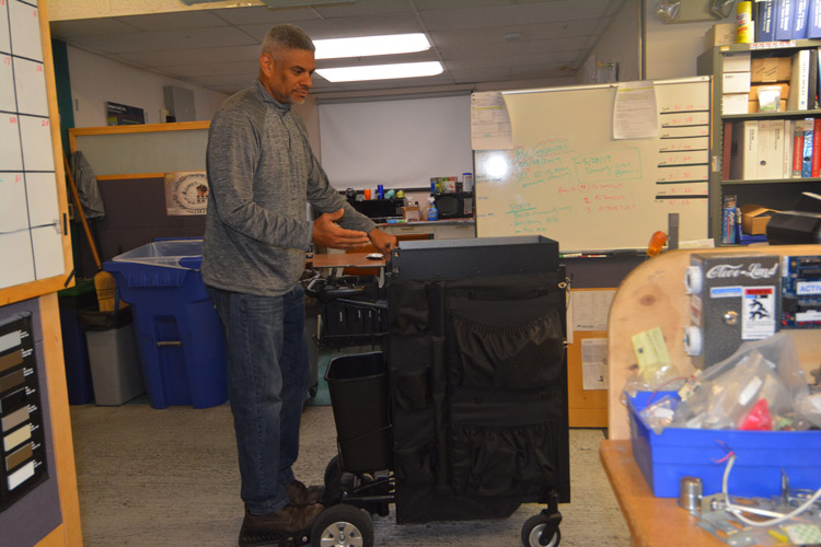 John Camello rides the motorized cart around the lock shop.