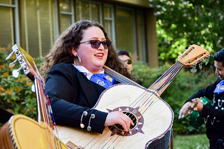 A woman in the mariachi plays the guitarrón in the mariachi.