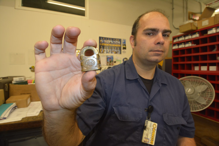 Nate Vincench holds up a heavy antique lock.