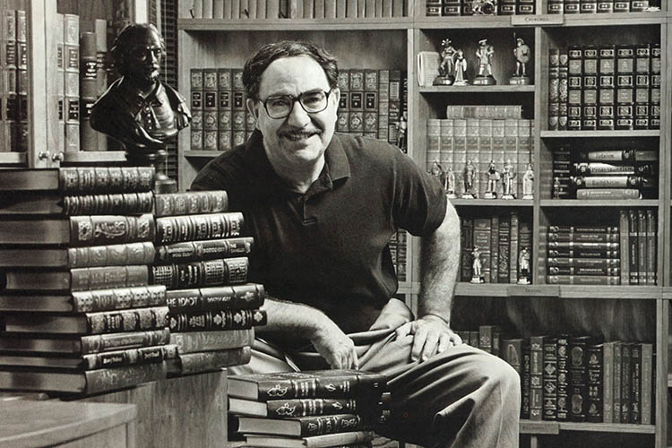 a man sits in front of books