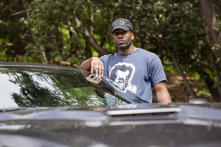 Russ Udé with his car in the Berkeley hills.