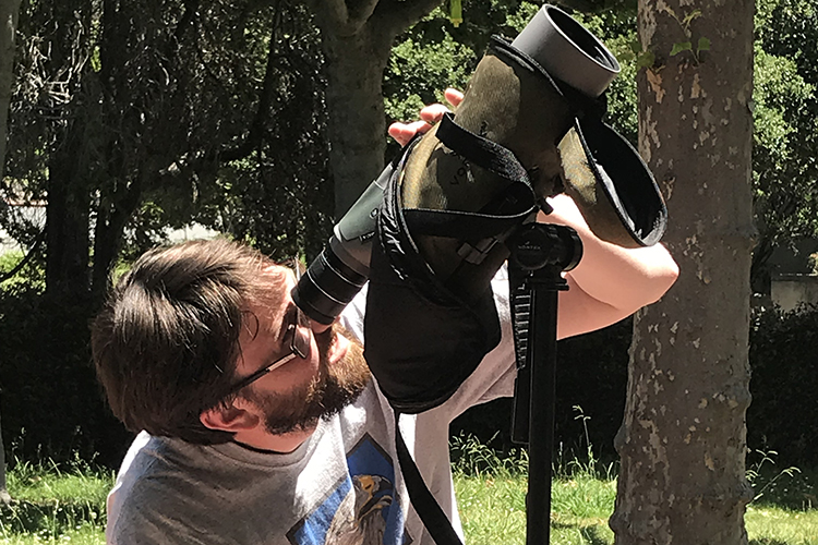 Sean Peterson looks at the falcons through a telescope.