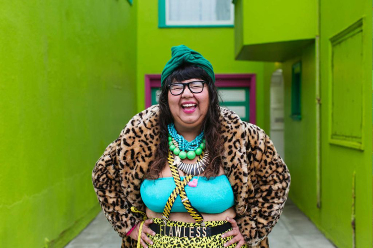 Virgie Tovar laughing wearing a leopard print jacket and a tube top
