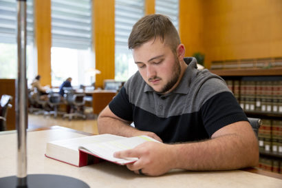 Blake reads a law book in the law library