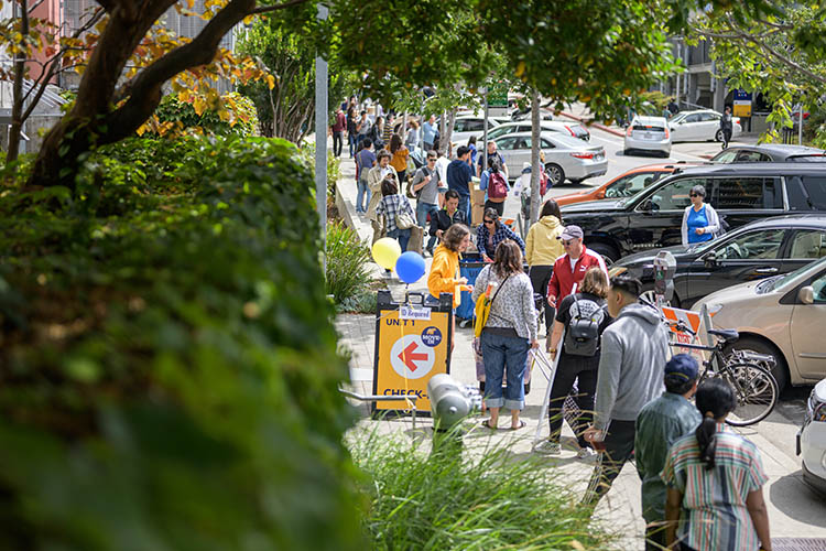 people gather on the sidewalk