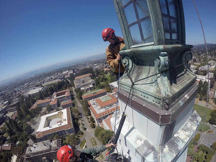 two people work on top of the tower