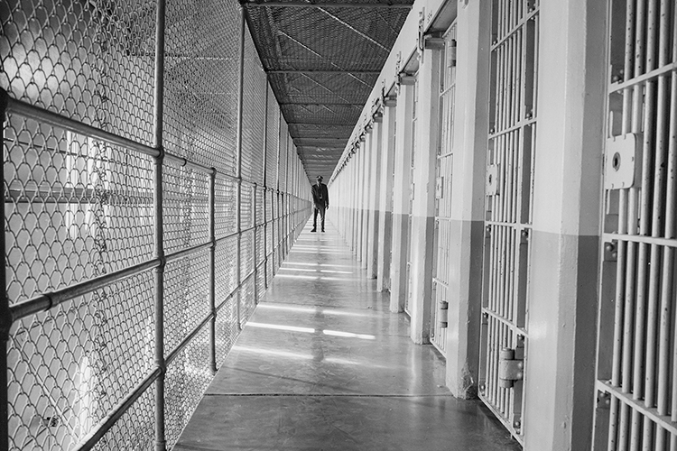 prison official standing at the end of a long hallway