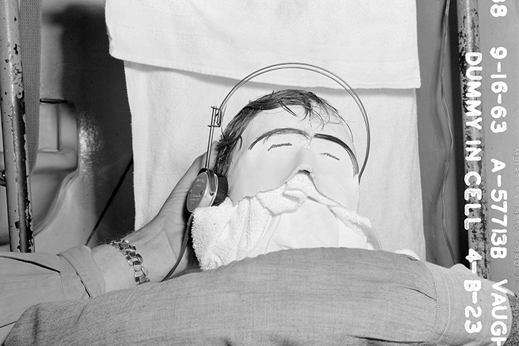 a dummy head is held up in a prison cell