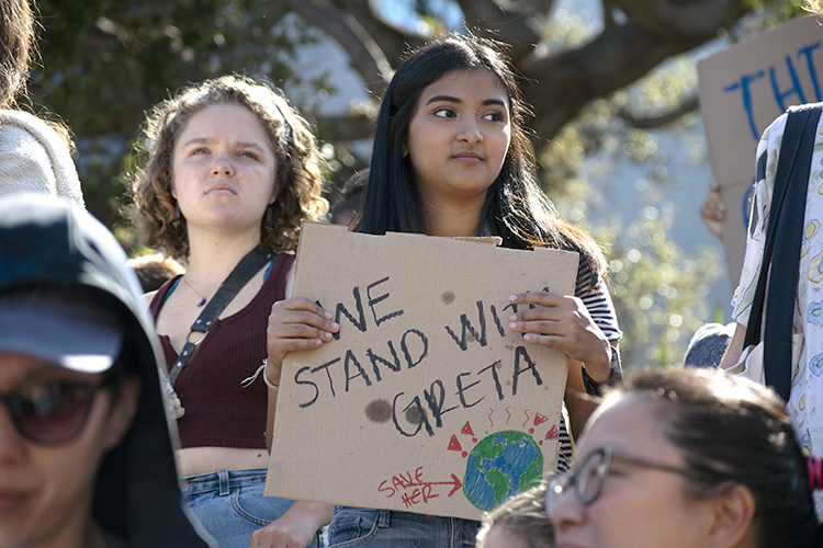 young student holding sign that says: 