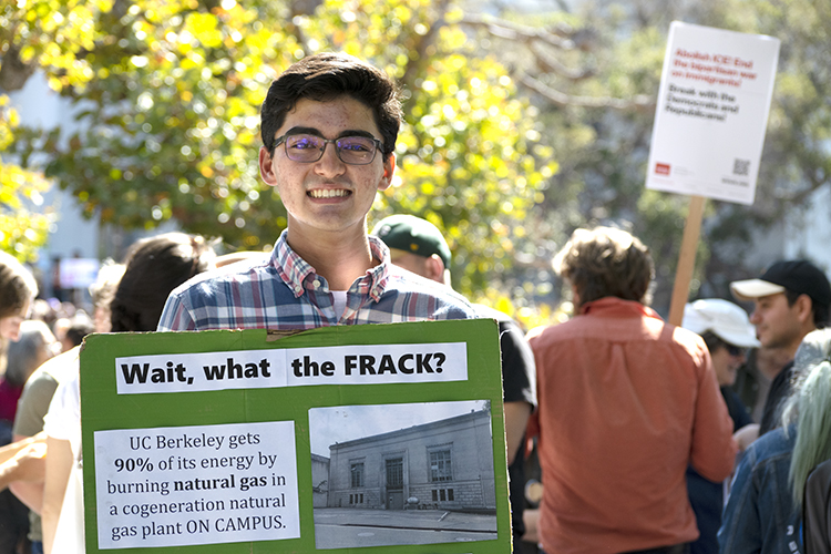 Conor Martin holding a sign at climate strike that says: 