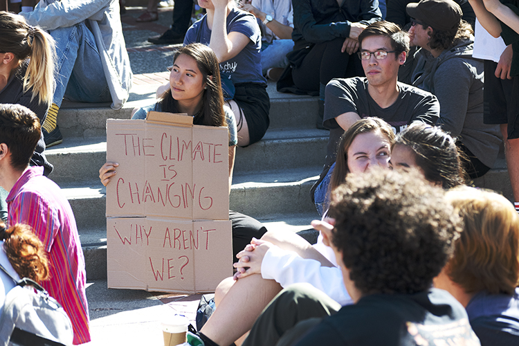 woman holding sign at climate strike that says 