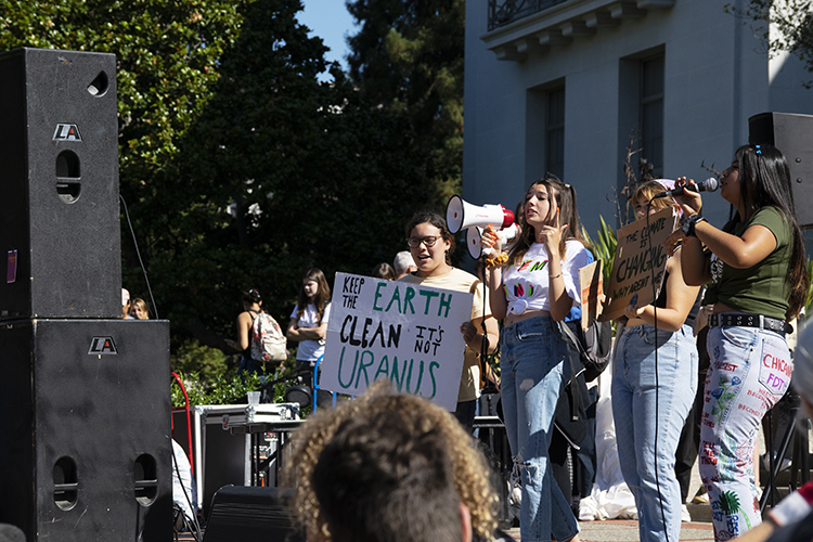 people speak on stage at climate strike