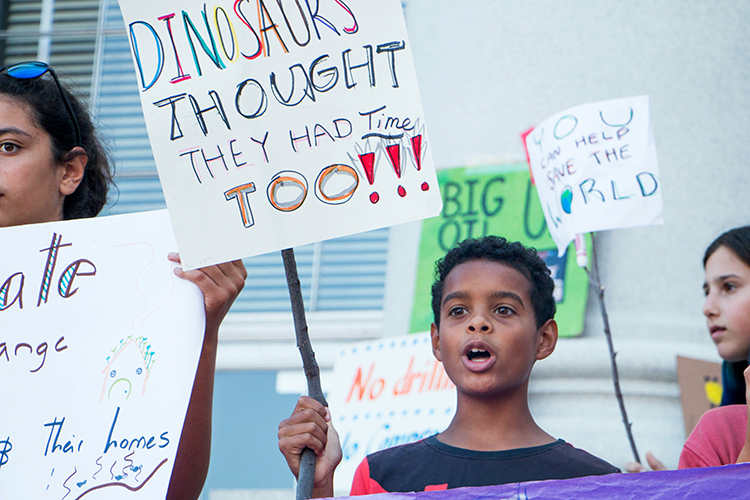 kid holds a sign that says 