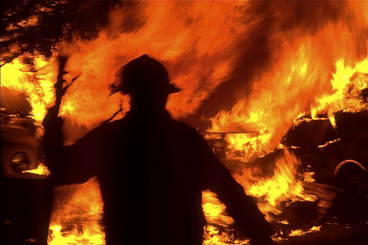 a silhouette of a firefighter surrounded by flames