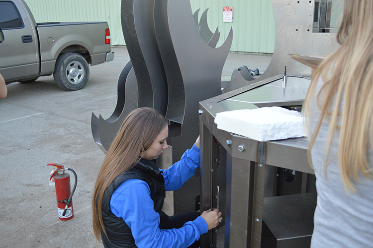 Claire Robbins, chair of the Rally Committee, works on new bonfire structure in Oakland.