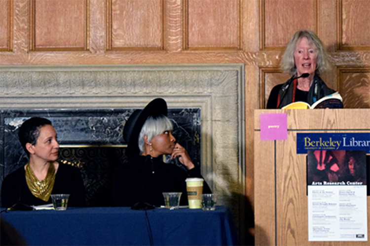 Lyn Hejiniam reads poetry at a podium while poets Indira Allegra and Chiyuma Elliott listen