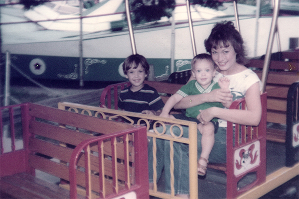 A mom with two young sons on a kids' train ride