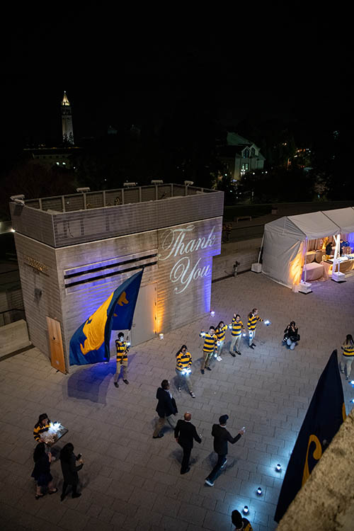 A group walks through the plaza at memorial stadium after dark