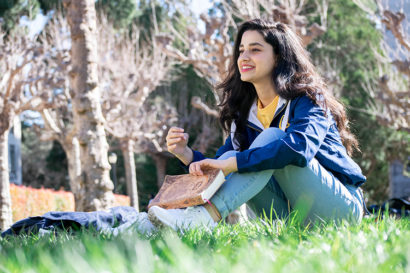 Maryam Karimi sits in grass smiling