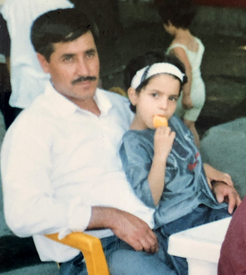 Maryam as a kid sitting on her dad's lap