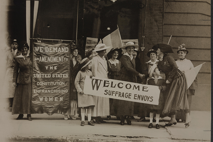 Archival photo of women holding women's suffrage signs