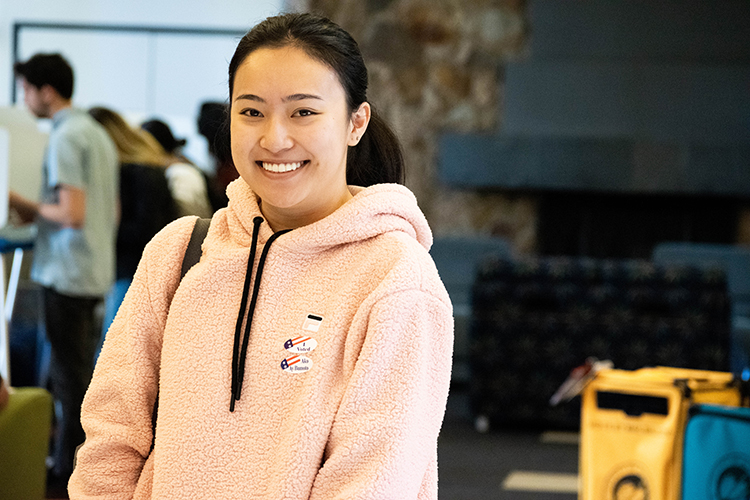 Female student wearing a pink sweater smiling