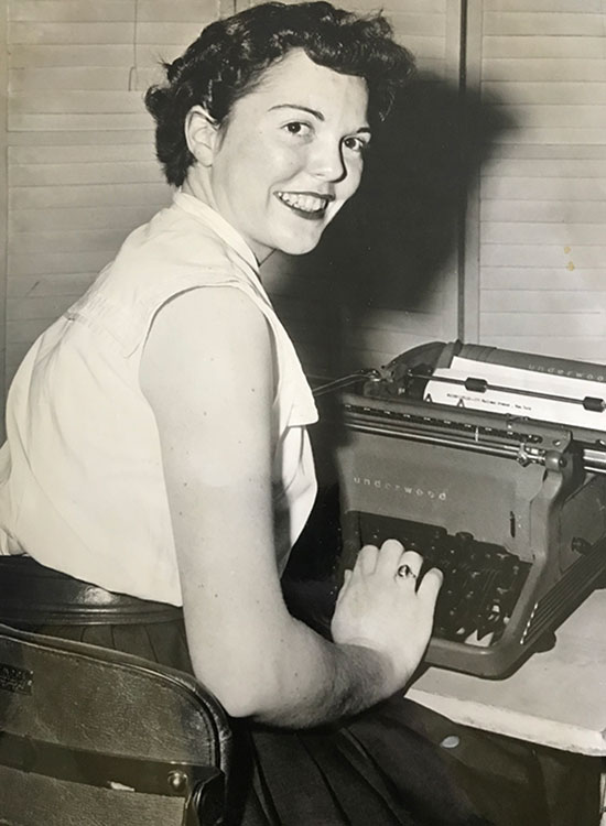 A photo of a woman at a typewriter