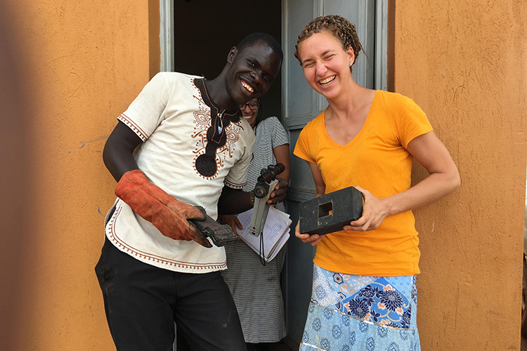 In Gulu, Uganda, Juliana Cabrera, a UC Berkeley undergraduate majoring in mechanical engineering, enjoys a laugh with Gulu University biosystems engineering student Felix Adupe after finishing an experiment at Takataka Plastics.