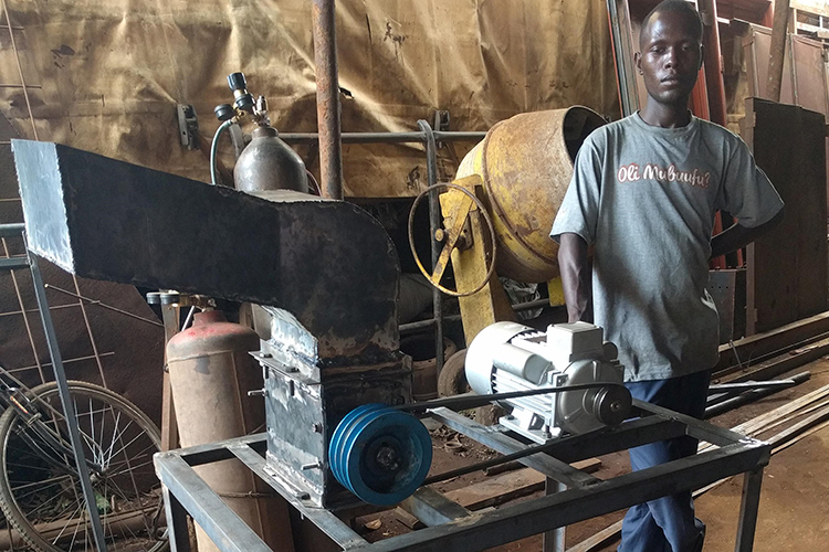Mugaiga Ronald, a Gulu University student who worked as an intern at Takataka Plastics, poses with the prototype shredding machine he worked on.