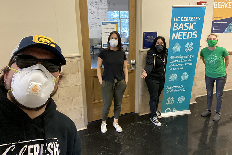 four people take a selfie in front of the UC Berkeley basic needs center
