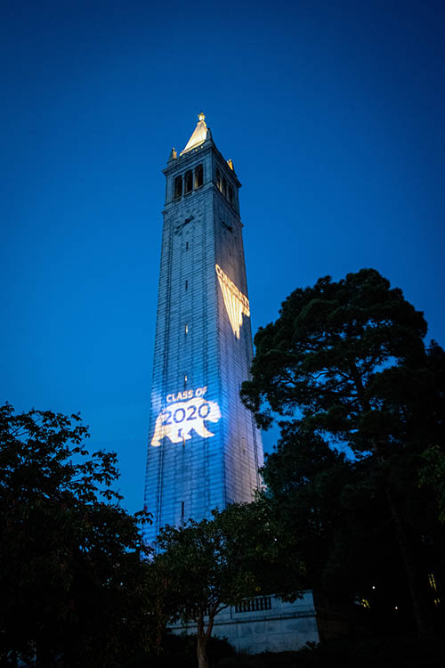 Sather Tower with a light projection saying 