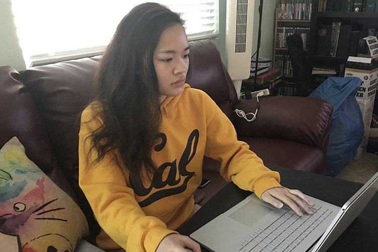 Nga Nguyen sits in front of a computer