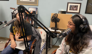 Two students wearing earphones and using recording equipment create a podcast in a recent Chicano Studies class.