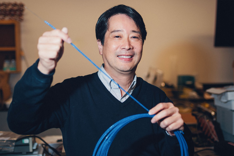 Kenichi Soga holding fiber-optic cable