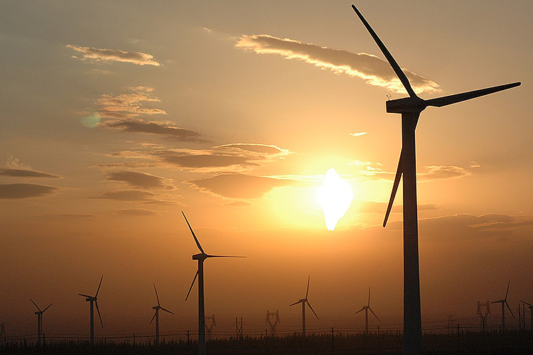 wind turbines silhouetted by sunset