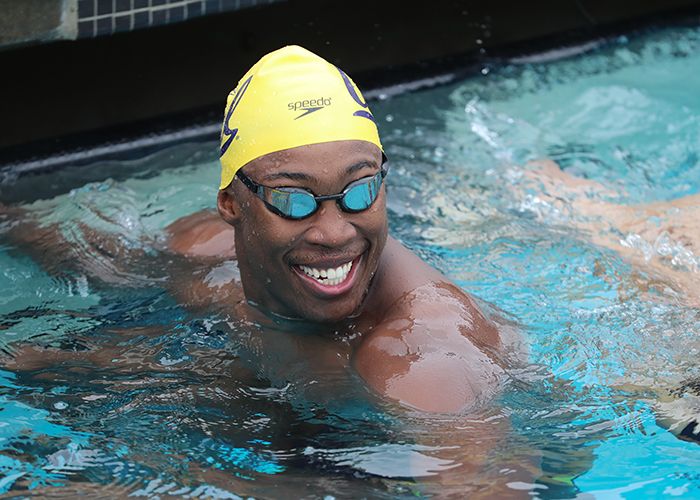 Reece Whitley smiling in the swimming pool after completing a race