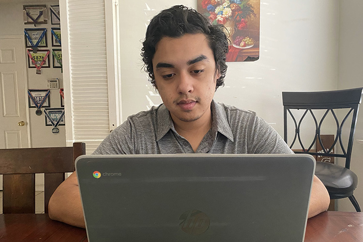 Student Anthony Meza works at home in Los Angeles during the COVID-19 crisis on his Chromebook laptop, which was loaned to him by the Student Technology Fund.