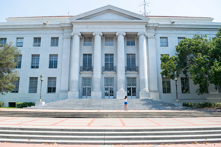 A student stands alone at the foot of the Sproul Hall steps during the coronavirus pandemic