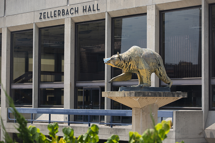 A mask is worn by a bear statue on Lower Sproul Plaza