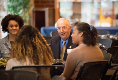 Bob Haas sitting at a table with students