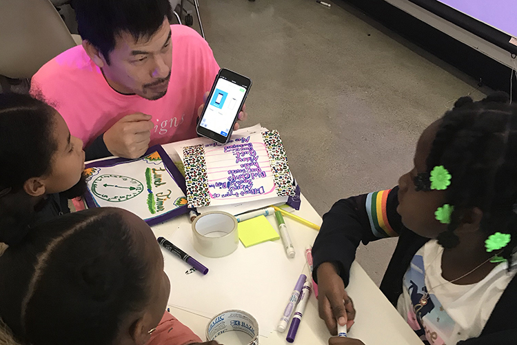 Young students at a table learning about mobile apps