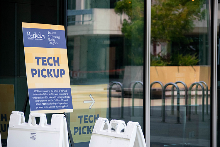 A sign points students to a tech pickup spot for the Student Technology Equity Program.