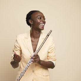 A woman smiling and holding a flute