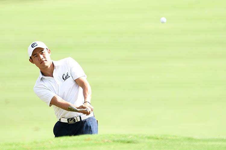 Collin Morikawa swings a golf club wearing a Cal golf uniform